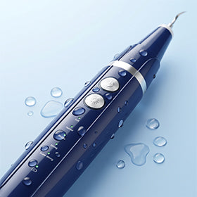 Ultrasonic dental plaque remover with water droplets showing sonic cleaning power